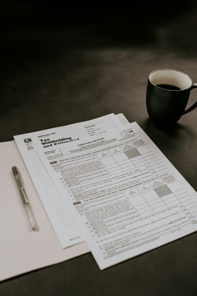 Two business owners reviewing printed insurance documents together in a small office setting.