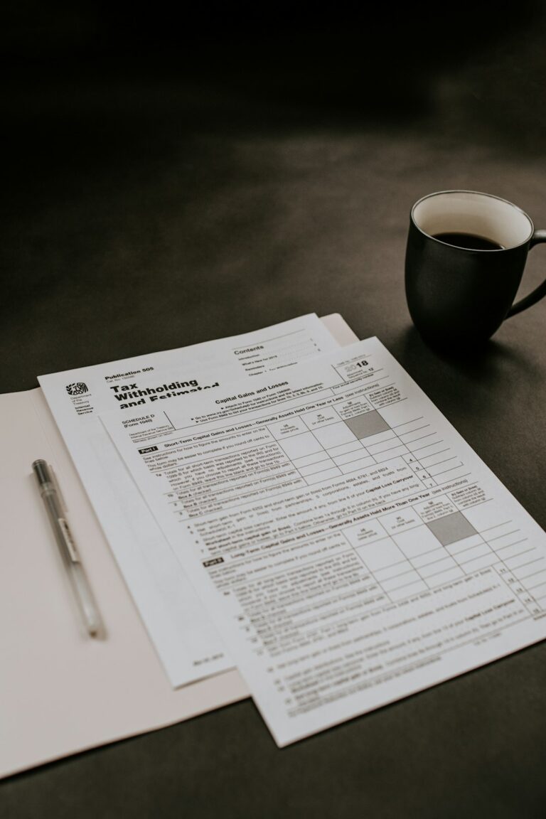 Two business owners reviewing printed insurance documents together in a small office setting.