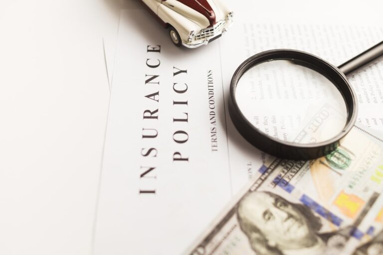 Small business owners reviewing insurance documents together at an office desk.