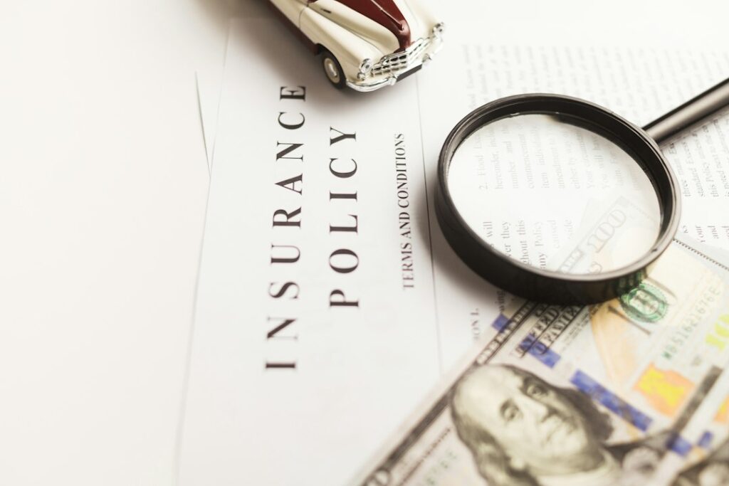 A family reviews insurance documents at a kitchen table beside a laptop and organized household records.