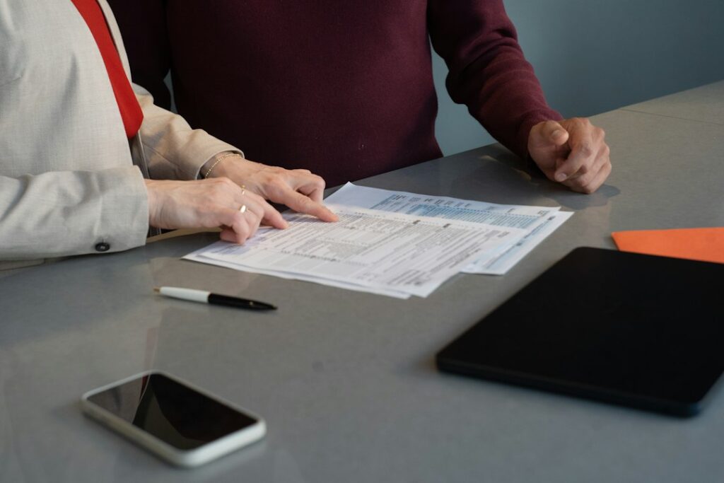 Person reviewing a disability insurance policy beside a calculator, notebook, and monthly household budget.