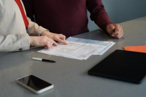 Person reviewing a disability insurance policy beside a calculator, notebook, and monthly household budget.